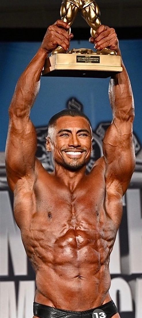 Dr. Suarez holding a first-place bodybuilding trophy
